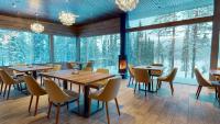 un ristorante con tavoli e sedie e grandi finestre di Kurula's Resort a Pyhätunturi