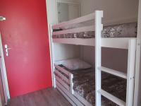 a room with two bunk beds and a red wall at Studio Le Grau-du-Roi, 1 pièce, 4 personnes - FR-1-307-123 in Le Grau-du-Roi