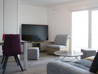 a living room with a tv and chairs and a table at Appartement La Rochelle, 3 pièces, 4 personnes - FR-1-246-588 in La Rochelle