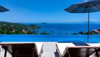 vistas a una piscina con sillas y sombrilla en Buzios Mar Hotel, en Búzios