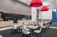 a restaurant with tables and chairs and red lights at Travelodge Hotel Sydney Airport in Sydney