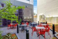 a patio with tables and chairs in front of a building at Travelodge Hotel Sydney Airport in Sydney
