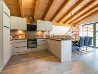 une cuisine avec des placards blancs et une salle à manger dans l&#39;établissement Pinzgau Lodge 2D, à Wald im Pinzgau