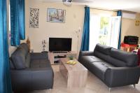 a living room with two leather couches and a television at Résidence Niccola in Vidauban