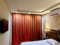 a bedroom with a red curtain and a bed at Hotel Nalba Jupiter in Jupiter