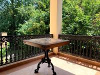 a table on a balcony with a view of trees at Hotel Nalba Jupiter in Jupiter