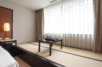 a room with a bed and a table in front of a window at Beitou Sweet Me Hot Spring Resort in Taipei