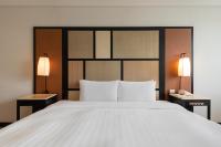 a bedroom with a large bed with two lamps at Beitou Sweet Me Hot Spring Resort in Taipei