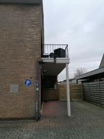 a balcony on the side of a brick building at Logies Lily in Oudenburg