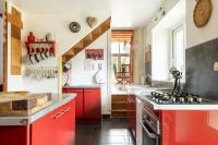 a kitchen with red cabinets and a red stove at Maison Meslaie - Maison pour 8 avec piscine in Beaumont-en-Véron