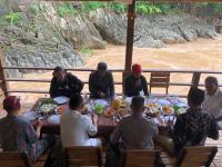 un gruppo di persone sedute attorno a un tavolo che mangiano cibo di Pekkae ecolodge and cafe a Libua