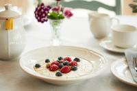 Eine Schüssel Joghurt mit Beeren auf einem Tisch in der Unterkunft Sid Valley Country House Hotel in Sidmouth