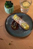 ein schwarzer Teller mit einem Stück Essen auf einem Tisch in der Unterkunft ibis Styles Les Houches Chamonix in Les Houches
