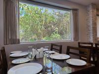 een eettafel met uitzicht op een raam bij Serene Sriperumbudur in Kāndūr