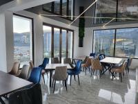 Un restaurante con mesas y sillas y grandes ventanales. en Вилно селище PARADISE VIEW, en Sarnitsa