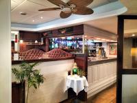 シェルブール・アン・コタンタンにあるLogis HOTEL RESTAURANT La Régenceのテーブルと天井扇風機のあるバー