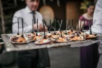 a tray of appetizers on a table with a waiter at A Quinta Da Auga Hotel Spa Relais & Chateaux in Santiago de Compostela