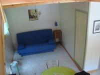 ein Wohnzimmer mit einem blauen Sofa und einem Tisch in der Unterkunft Gîte le soleil d&#39;eau 3 in Meyras