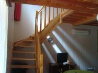 eine Holztreppe in einem Zimmer mit einem TV in der Unterkunft Gîte le soleil d&#39;eau 3 in Meyras