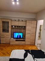 a living room with a flat screen tv and wooden cabinets at Kineski zid in Zenica