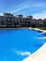 a large blue swimming pool in front of a building at Apartmento Apartaclub La Barrosa 223 in Chiclana de la Frontera