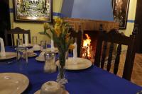 una mesa con un paño de mesa azul y un jarrón de flores en Hotel Palacio de Moctezuma, en San Cristóbal de Las Casas