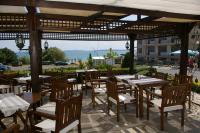 een restaurant met tafels en stoelen en uitzicht op de oceaan bij Family Hotel Berlin Beach Sveti Vlas in Sveti Vlas