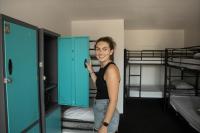 a woman standing next to a blue cabinet in a room at Nomads St Kilda in Melbourne