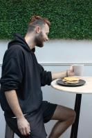 a man sitting at a table with a cup of coffee at Nomads St Kilda in Melbourne