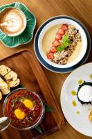 een tafel met borden eten en een kopje koffie bij Deep Roots Dive & Yoga Resort in Nusa Penida