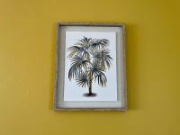 a picture of a palm tree on a yellow wall at La Renaissance in Bayeux