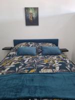 a bed with a blue comforter and pillows at LES MIRABELLES in Metz
