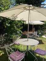 a table and chairs with an umbrella in the grass at Mas de la Sacristière in Jonquerettes