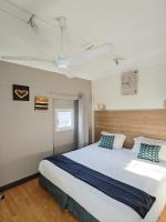 - une chambre avec un grand lit blanc et des oreillers bleus dans l&#39;établissement Les Lavandes, à La Ciotat