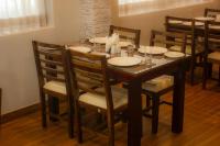 een eettafel en stoelen met borden erop bij Serene Sriperumbudur in Kāndūr