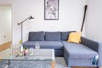 a living room with a blue couch and a glass table at City View Apartments Birmingham City Centre in Birmingham