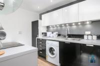 a kitchen with a washing machine and a washer at City View Apartments Birmingham City Centre in Birmingham