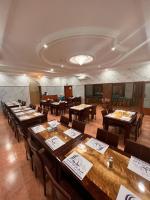 a dining room with wooden tables and chairs at Shorfet Al Alamin Hotel in Al Ḩamrāʼ