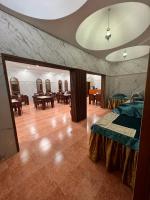 a room with a bed and tables and chairs at Shorfet Al Alamin Hotel in Al Ḩamrāʼ