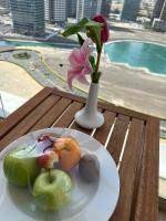 a plate of fruit and a vase with a flower on a table at Treppan Hotel & Suites By Fakhruddin in Dubai