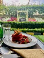 a plate of pancakes and fruit on a table at Treppan Hotel & Suites By Fakhruddin in Dubai