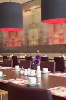 a dining room with tables and chairs with purple flowers at IntercityHotel Bonn in Bonn