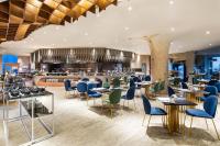 スラバヤにあるMORAZEN Surabayaのテーブルと椅子とバーのあるレストラン