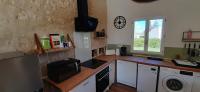 a kitchen with a counter and a sink and a clock at le clos des chevaliers in Pons