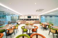 a restaurant with tables and chairs and a kitchen at The Beacon Hotel Visakhapatnam in Visakhapatnam