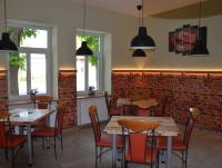 Un restaurante con mesas y sillas y una pared de ladrillos. en Guesthouse Pr'Šefu, en Brežice