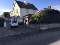 a white car parked in front of a white house at Garden Suite in Rhuddlan