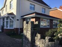 a house with a stone wall in front of it at Garden Suite in Rhuddlan