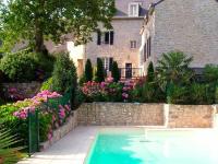 a swimming pool in front of a house with flowers at Résidence Ti An Amiral in Bénodet