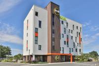 un edificio blanco alto con un reloj en él en B&amp;B HOTEL La Roche-sur-Yon, en Mouilleron-le-Captif